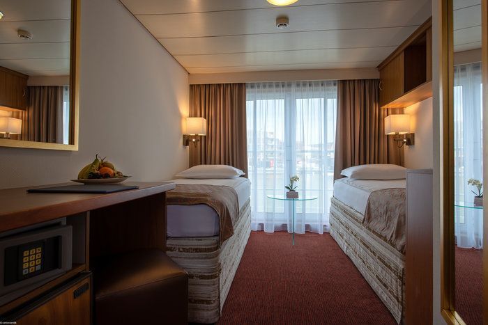 Zweibett-Außenkabine mit französischem Balkon auf einem Flusskreuzfahrtschiff.