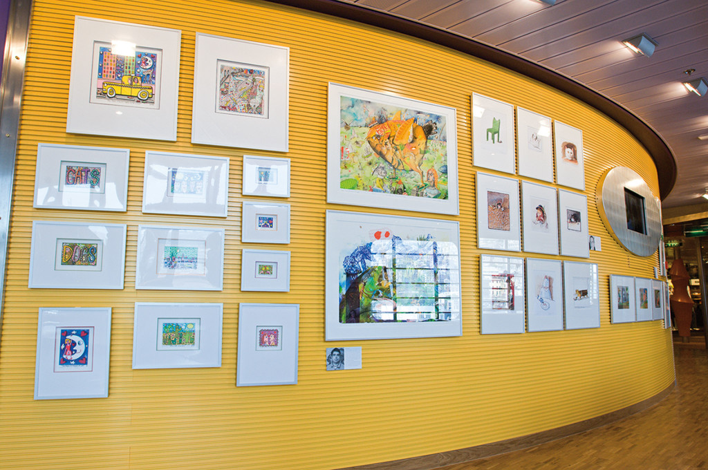 Kunstgalerie mit bunten Kinderzeichnungen auf gelber Wandfläche
