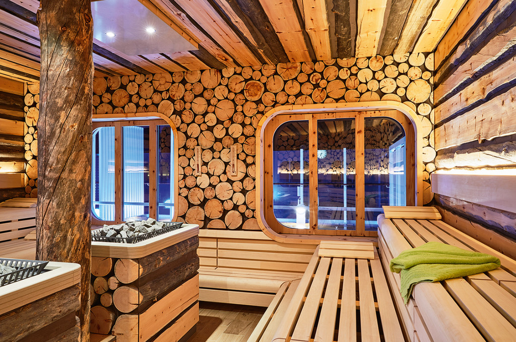 Finnische Sauna mit natürlichen Holzwänden und Sitzflächen für Wellnessbereich.
