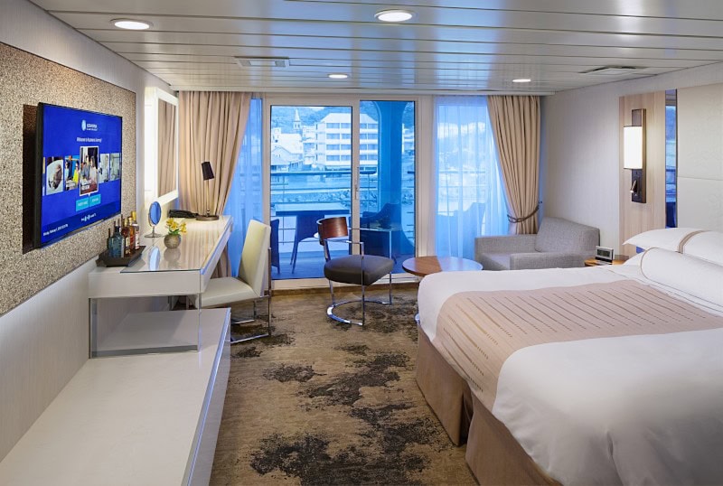 Club Continent Suite auf der Azamara Journey mit Doppelbett, Wohnbereich und Balkon