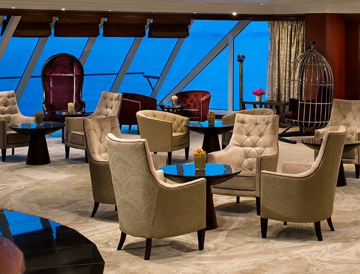 Elegante Lounge mit großen Fenstern, komfortablen Sesseln und Meerblick