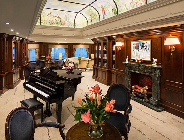 Elegante Lounge mit großem Kamin, komfortablen Sesseln und Meerblick