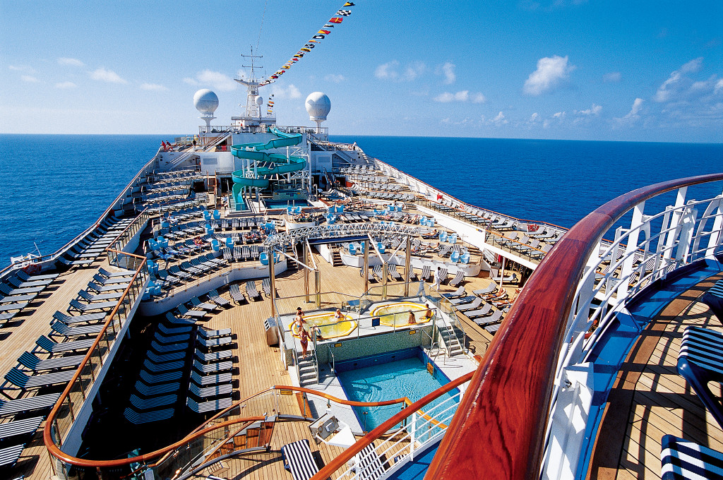 Lido Deck auf der Carnival Conquest mit Liegen, Pool und rotem Kamin