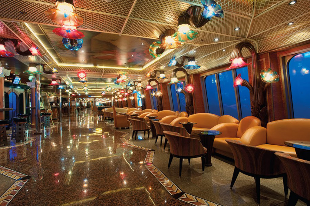 Lounge-Bereich auf der Carnival Conquest mit bequemen Sesseln und Meerblick