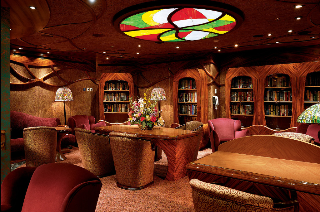 Bibliothek und Lounge auf der Carnival Conquest mit Holzmöbeln und Bücherregalen