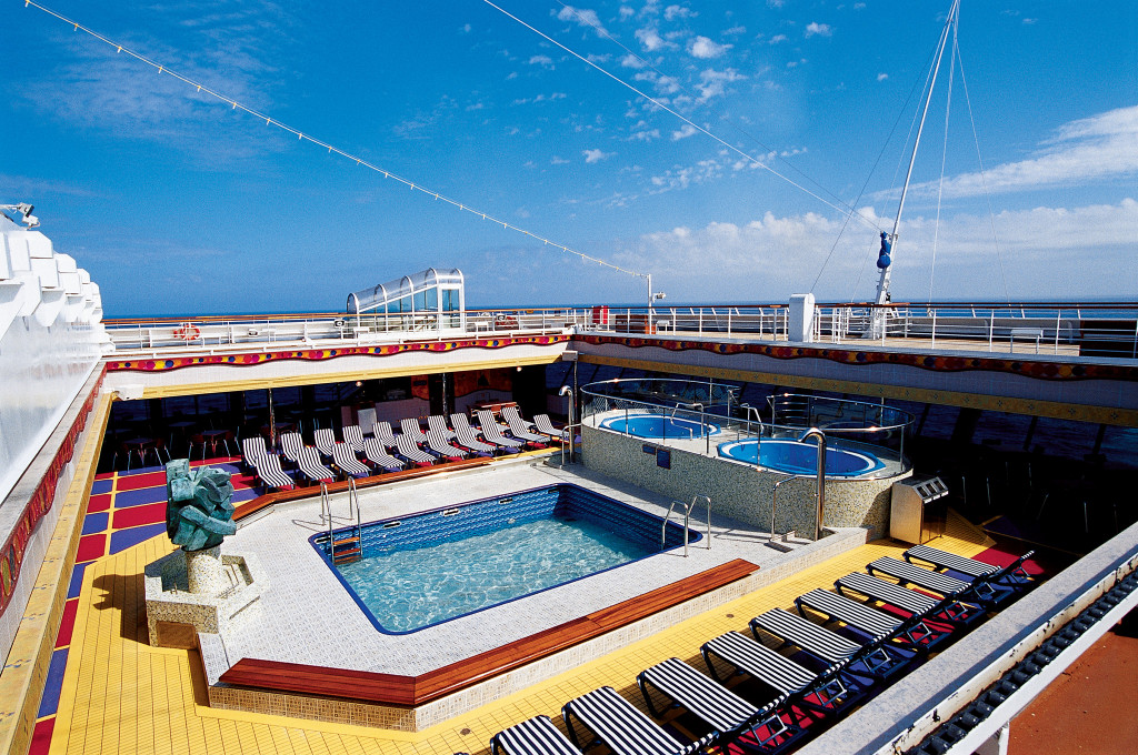 Swimmingpool auf der Carnival Conquest mit Liegestühlen und sonnigem Außendeck