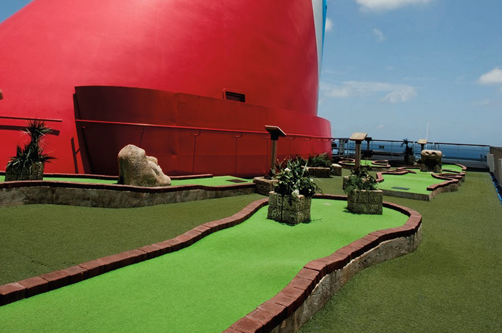 Minigolfanlage auf der Carnival Conquest mit Blick auf das Meer und die Reling.