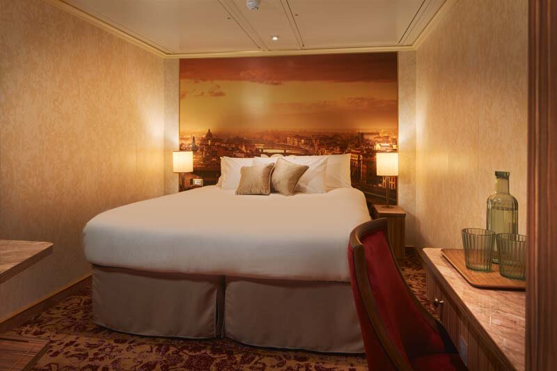 Innenkabine auf der Carnival Firenze mit Doppelbett und modernem eleganten Design.