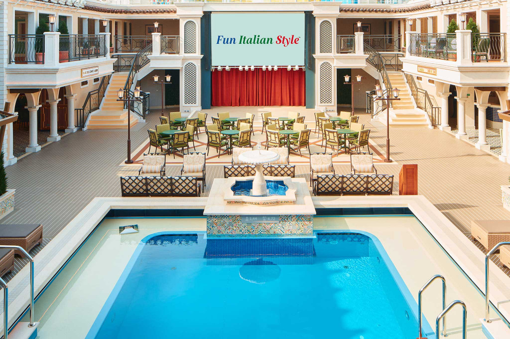 Pooldeck der Carnival Firenze mit großem Swimmingpool, Liegestühlen und Freiluftlounge.