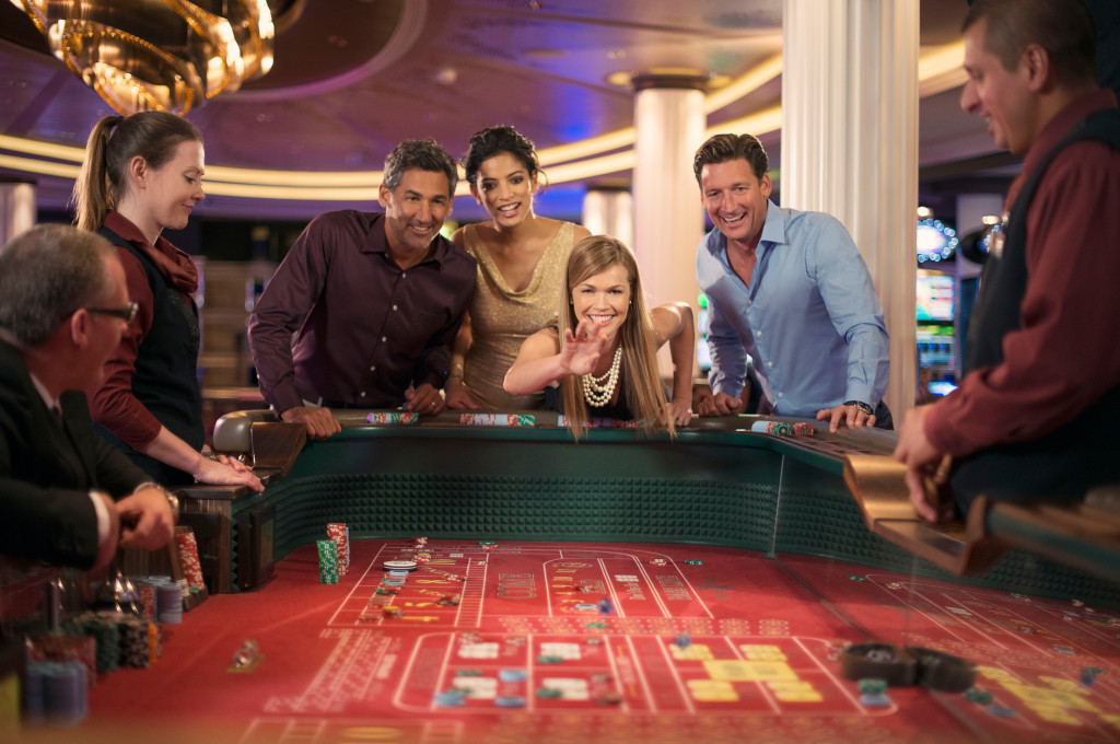Gäste spielen an der Casinotisch unter Kristallleuchtern in der Celebrity Reflection.