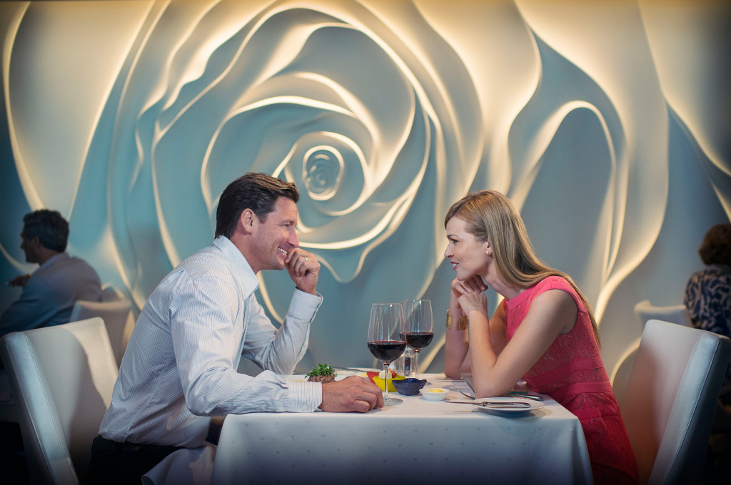Paar sitzt im eleganten Blu Restaurant mit modernem Wanddesign und Weingläsern.