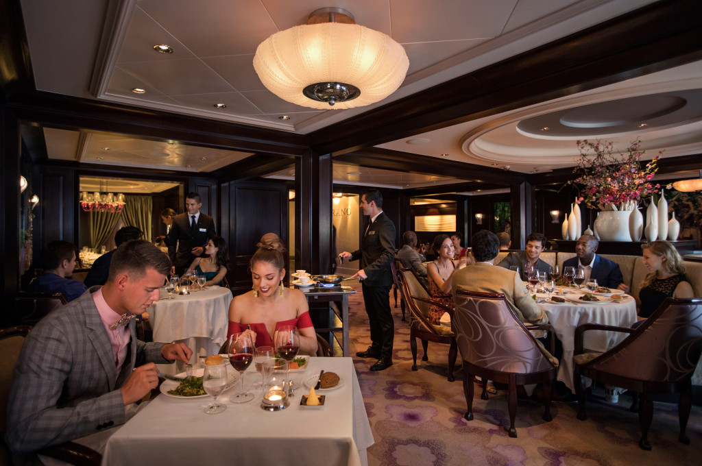 Das Murano Restaurant mit eleganten Deckenglampen, aufgedeckten Tischen und servierendem Personal.