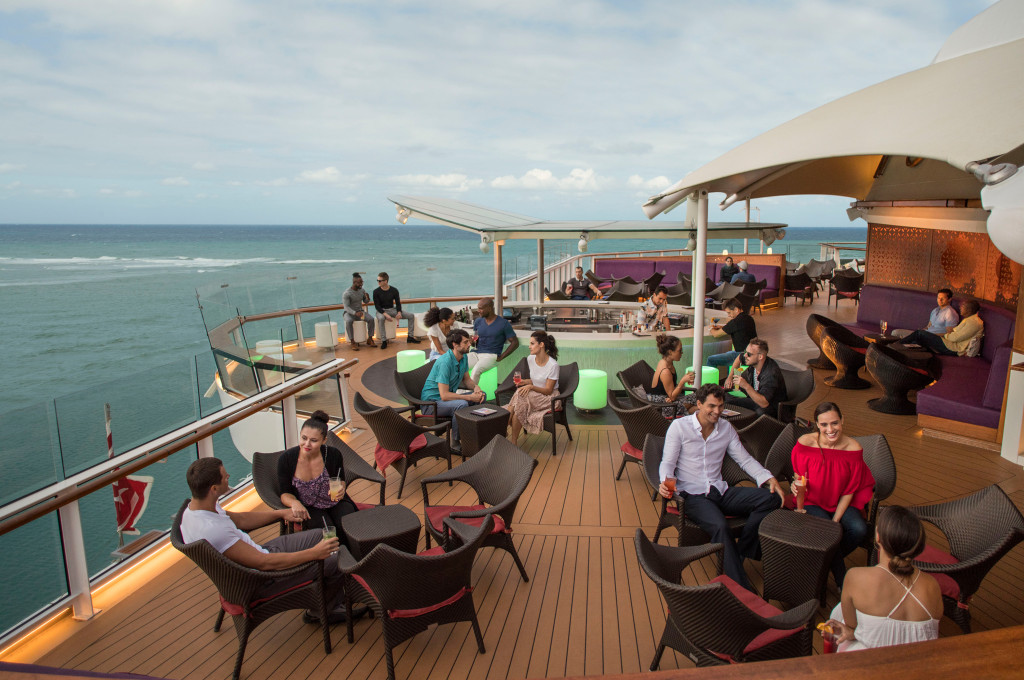 Gäste genießen die Sunset Bar auf dem Außendeck mit Meerblick und Sonnenschutz.