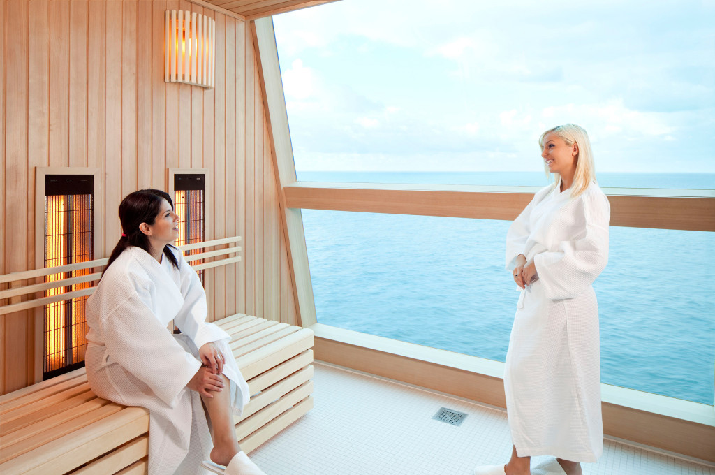 Gäste entspannen in der Sauna mit Infrarot-Heizern, Holzausstattung und Meerblick.
