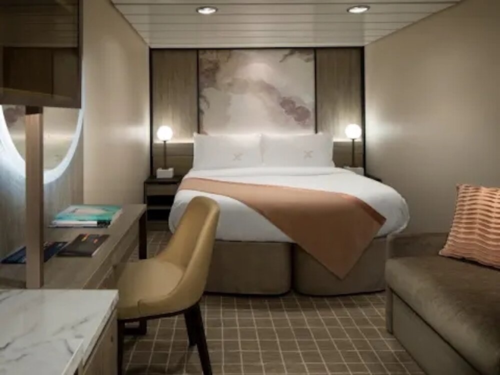 Moderne Innenkabine mit Doppelbett, Kunstwerk am Kopfteil und Schreibtischbereich auf der Celebrity Summit