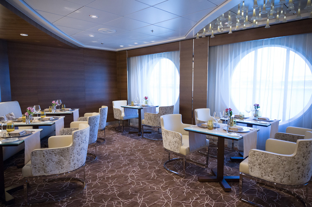 Exquisites Luminae Restaurant mit großen Fenstern und eleganter Tafel für Gäste der Hochseekreuzfahrt.