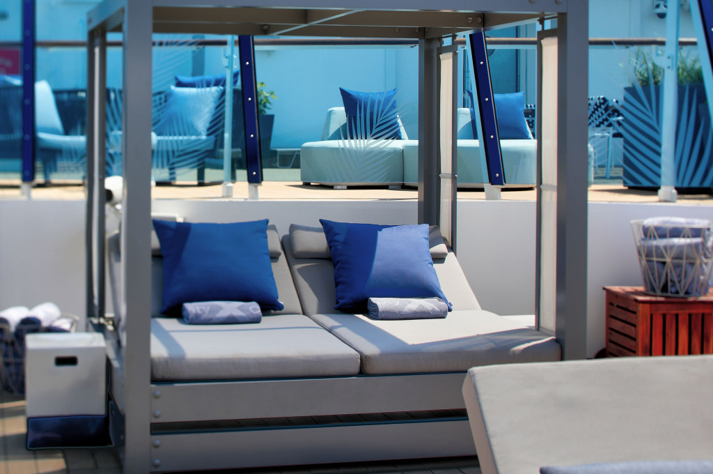 The Retreat Sundeck mit bequemen Liegen und modernem Himmelsbett für Premium-Gäste der Hochseekreuzfahrt.