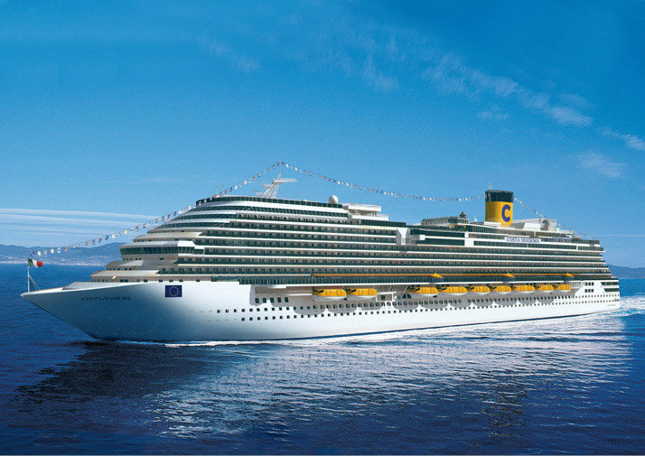 Kreuzfahrtschiff mit Flaggenschmuck in voller Fahrt auf dem Meer