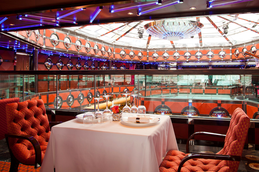 Costa Fascinosa Club Restaurant Fascinosa mit weißen Tischdecken, roten Stühlen und Meerblick.