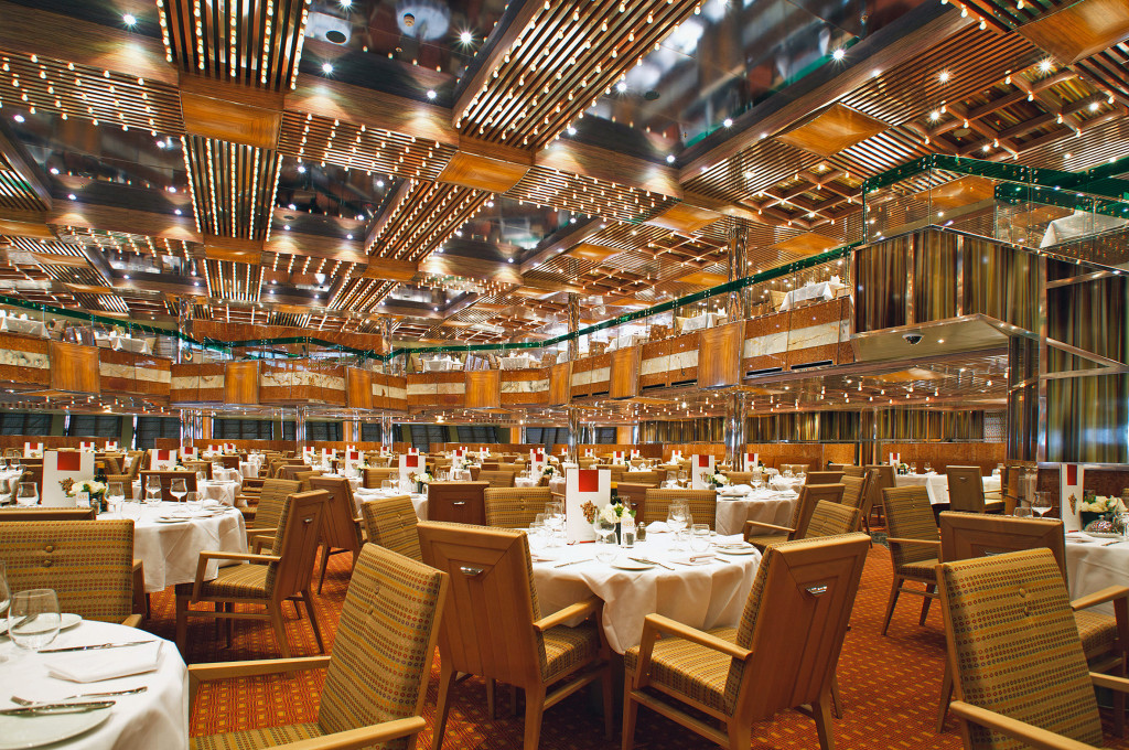 Costa Fascinosa Il Gattopardo Restaurant mit gedeckten Tischen, Holzeinrichtung und Kronleuchtern.