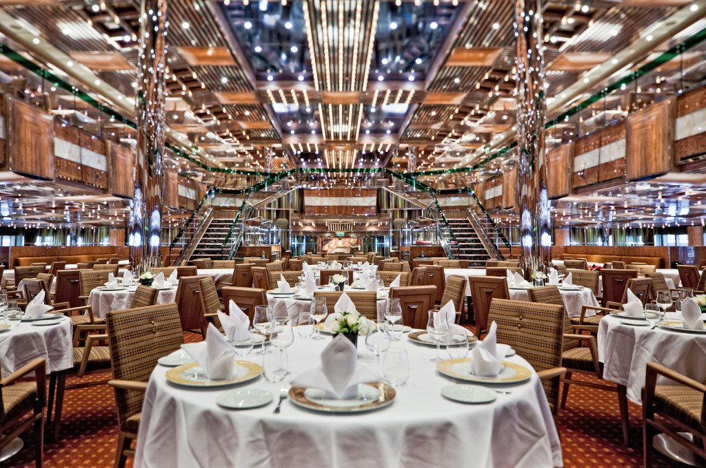 Costa Fascinosa Otto e mezzo Restaurant mit mehrstöckiger Architektur, gedeckten Tischen und Kronleuchtern.