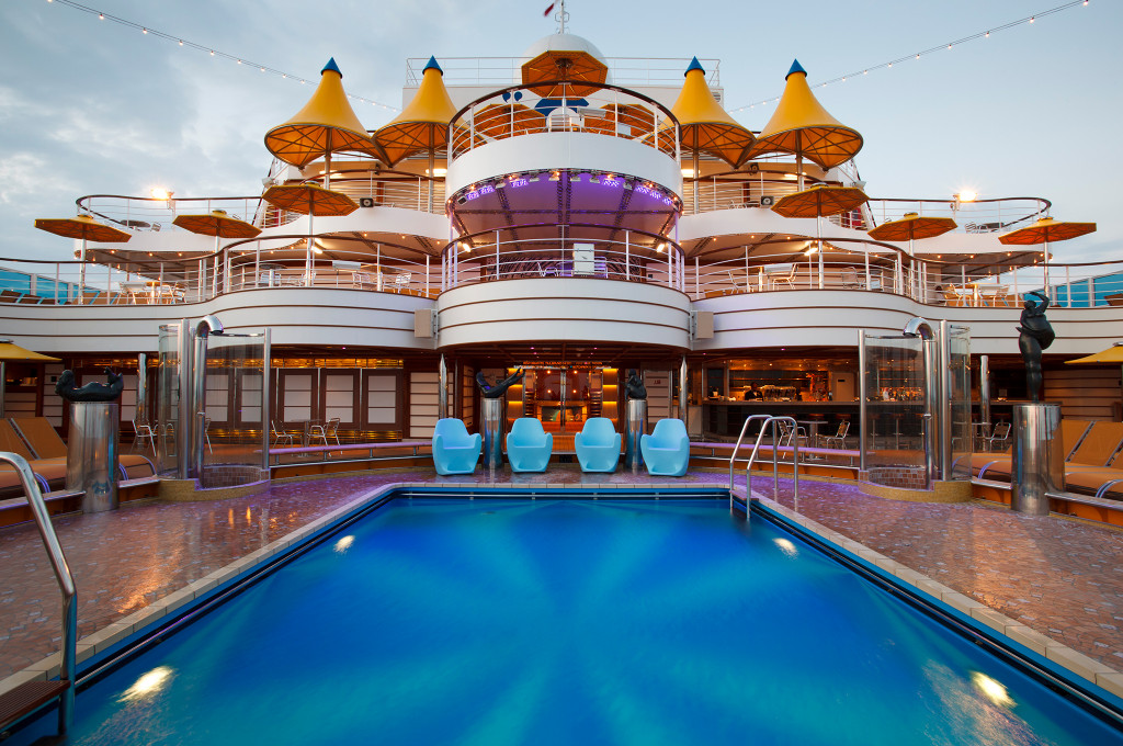 Costa Fascinosa Poolbereich auf dem Sonnendeck mit blauem Wasser, Liegestühlen und Schiffsoberbau.