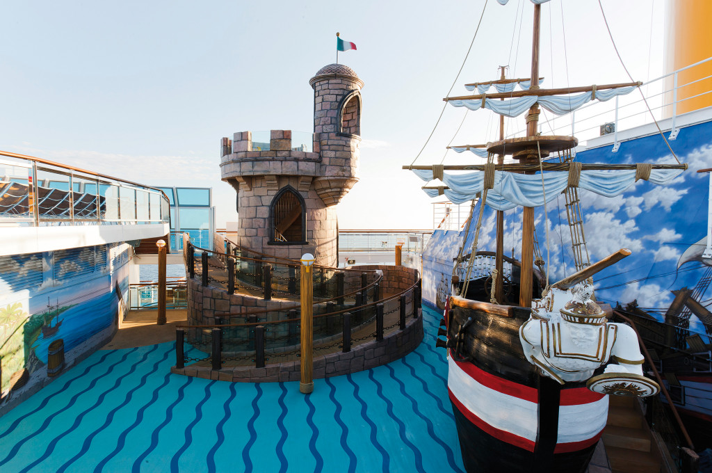 Kinderspielbereich auf dem Außendeck mit nachgebauter Burg und Piratenschiff auf blauem Wellenboden