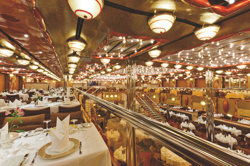 Opulentes zweistöckiges Hauptrestaurant mit goldener Deckengestaltung, Lichterketten und weiß gedeckten Tischen