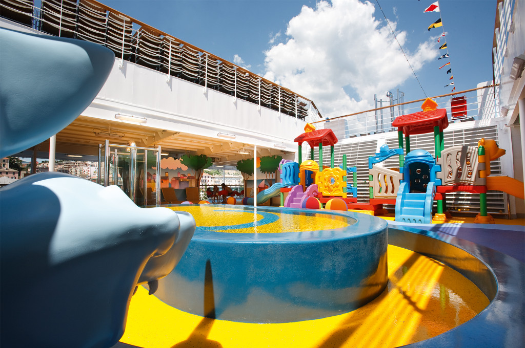 Squok Club Kinderspielbereich mit buntem Spielgerät, Rutschen und farbigen Wasserspielen an Deck.
