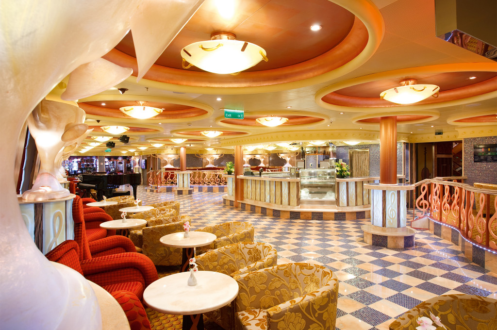 Caffetteria mit eleganten Sitzbereichen, beleuchteter Decke und modernem Design auf der Costa Pacifica.