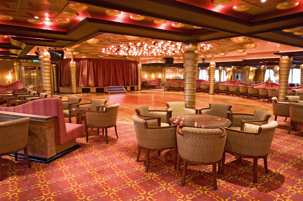 Grand Bar Apollo mit roter Decke, goldenen Elementen, braunen Sesseln und moderner Innenausstattung.
