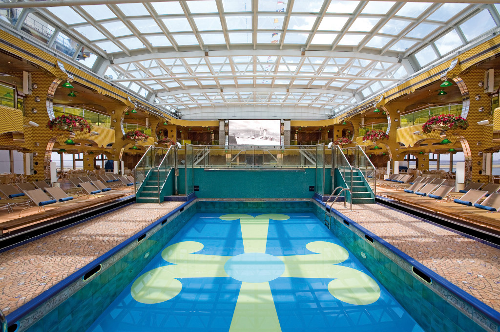Swimmingpool mit Badegästen und Liegestühlen auf einem Kreuzfahrtschiff