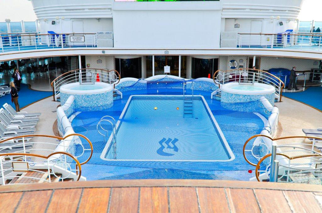 Poolbereich mit Schwimmbecken, Whirlpools und Liegestühlen auf der Grand Princess.