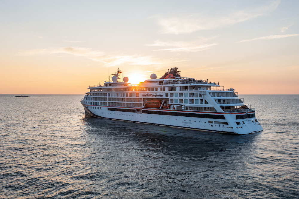 Außenansicht der HANSEATIC nature auf hoher See bei Sonnenuntergang