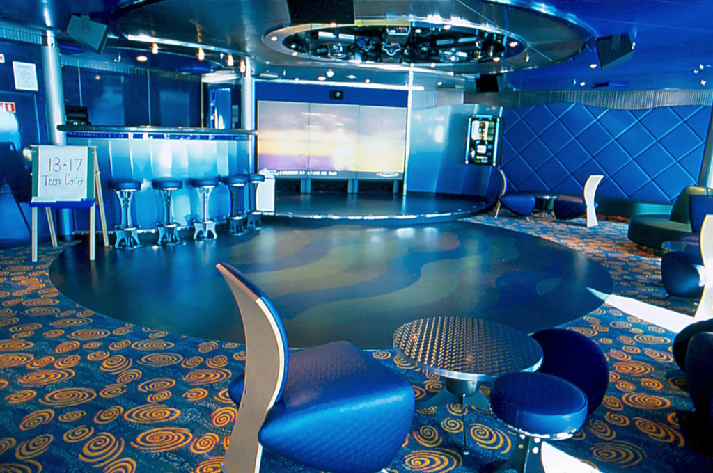 Modernes Kids Club Spielzimmer mit blauer Dekoration und Spielbereichen auf der Island Princess.