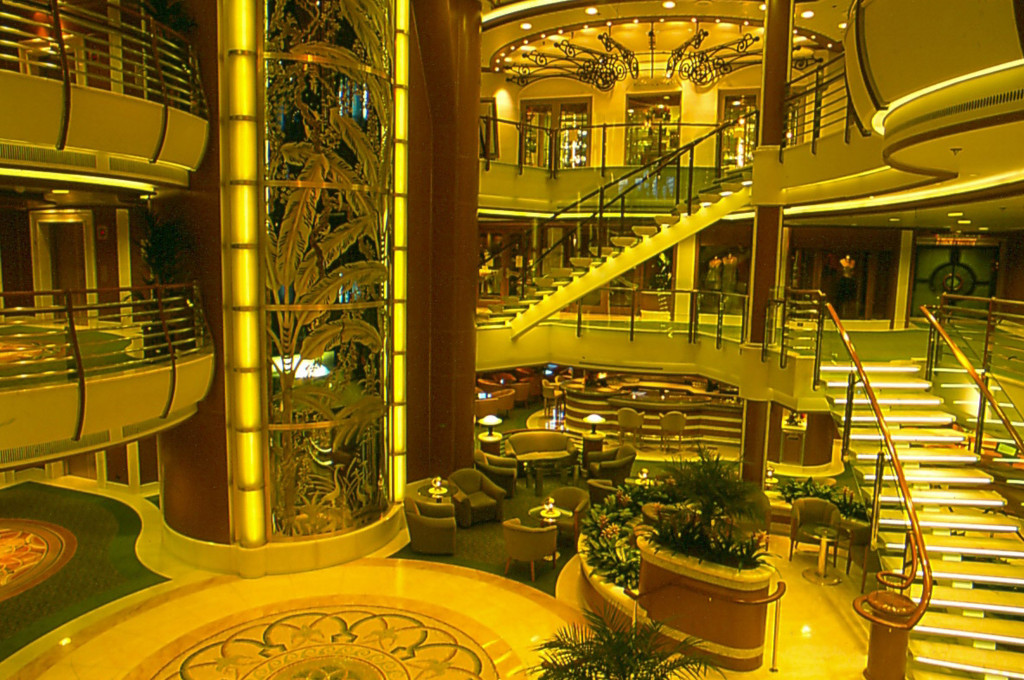 Glänzendes Atrium mit mehrgeschossigen Treppen und goldener Beleuchtung auf der Island Princess.