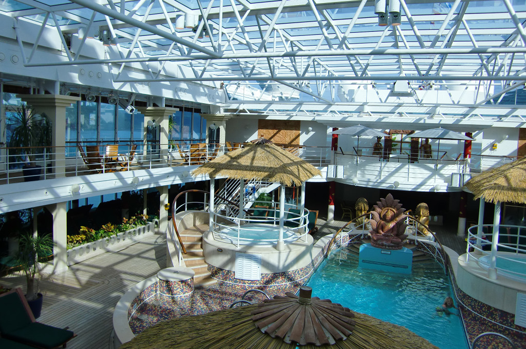 Großer Swimmingpool mit modernem Glasdach-Atrium und Schalunen auf der Island Princess.