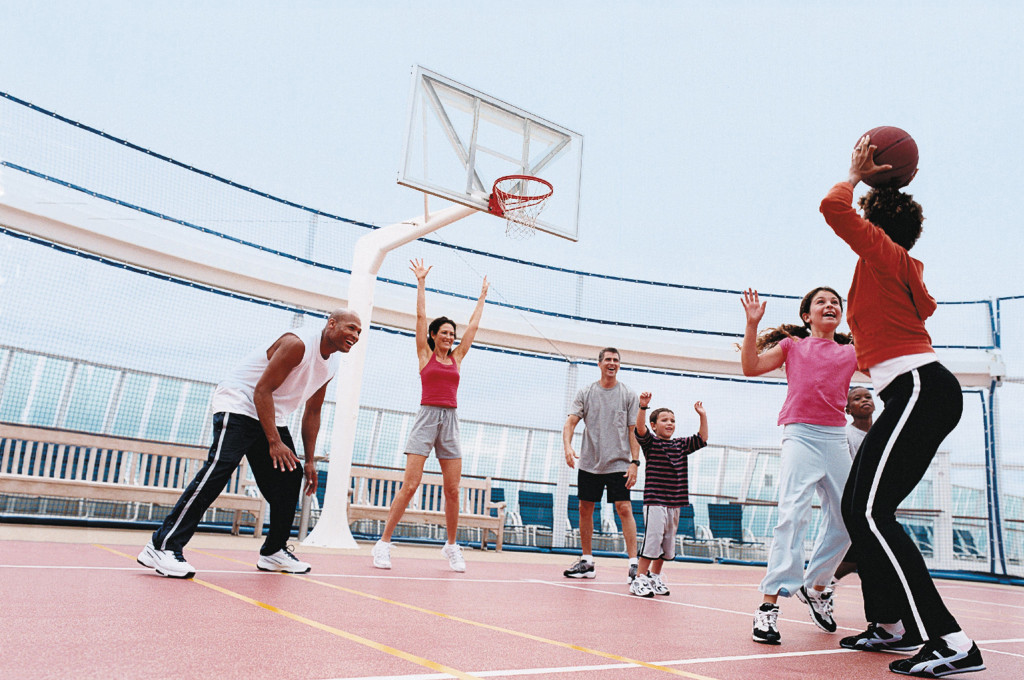Familien und Kinder spielen Basketball auf dem Sportdeck des Schiffes unter freiem Himmel.