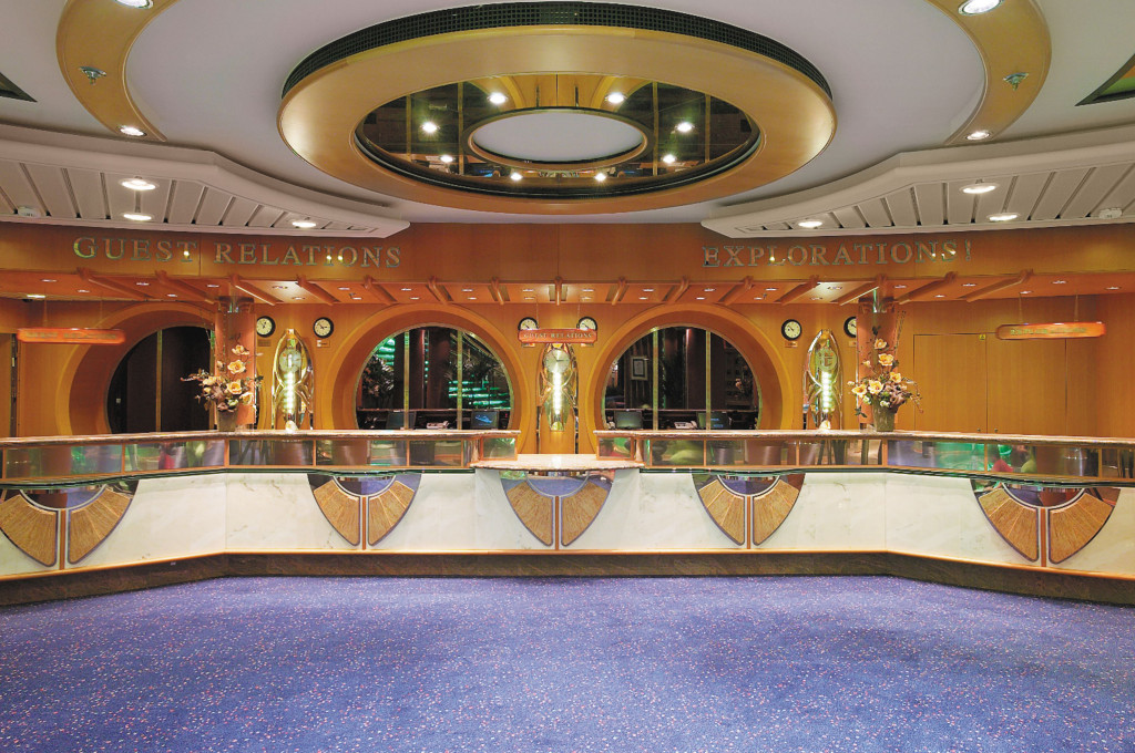 Rezeptionsbereich Guest Relations mit geschwungenem Tresen und runden Durchgängen in goldenen Farbtönen.