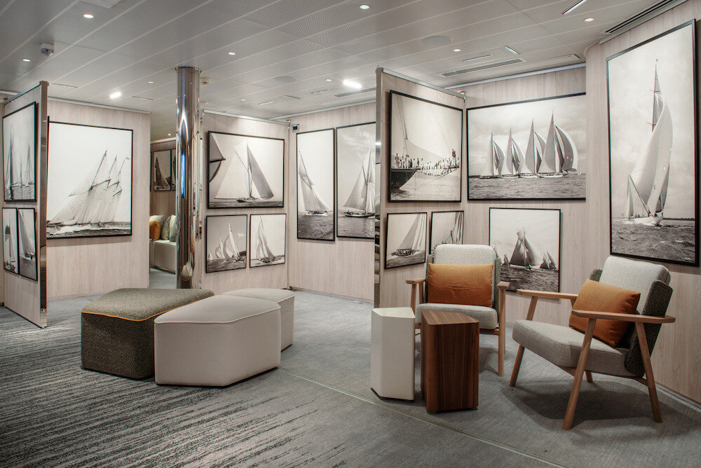 Kunstgalerie der Le Bellot mit schwarz-weißen Segelboot-Fotografien und modernen Loungesessel