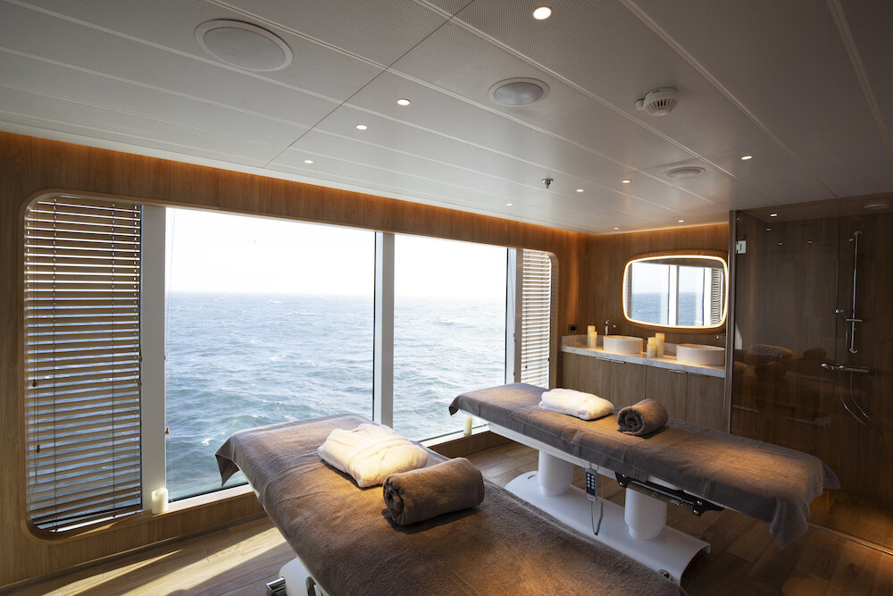 Spa-Behandlungsraum der Le Bellot mit zwei Massageliegen und Panoramablick auf das Meer