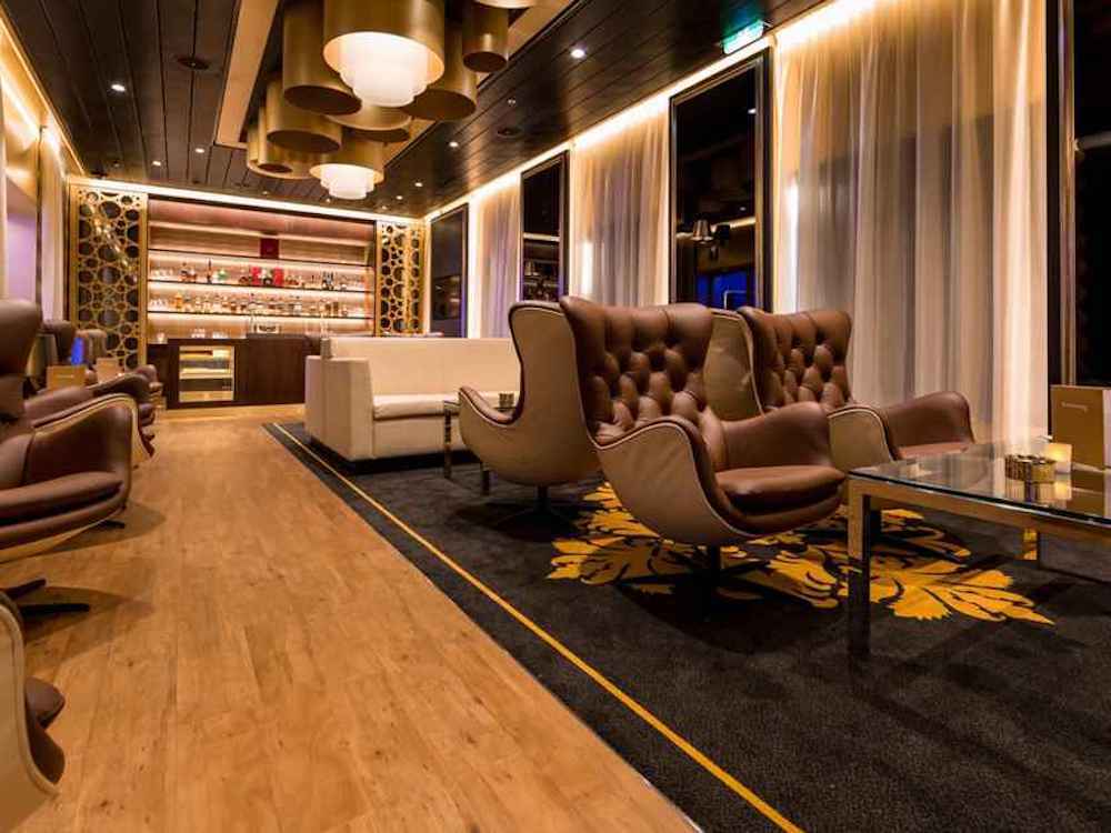 Rauchersalon auf der Mein Schiff 3 mit ledernen Chesterfield-Sesseln, Zigarrenablagen und gediegener Bar.