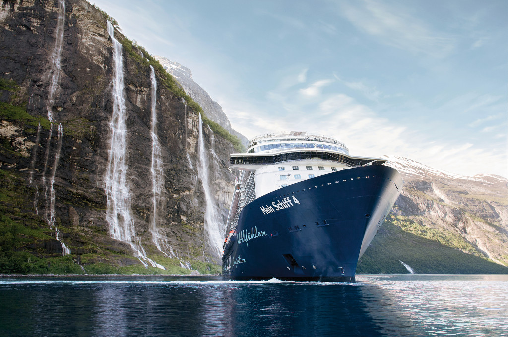 Mein Schiff 4 in einem norwegischen Fjord mit beeindruckenden Wasserfällen und Bergkulisse.