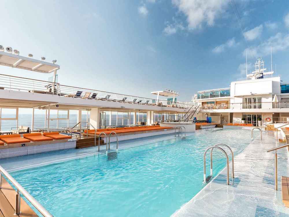 Außenpool auf der Mein Schiff 4 mit Liegestühlen und Meer