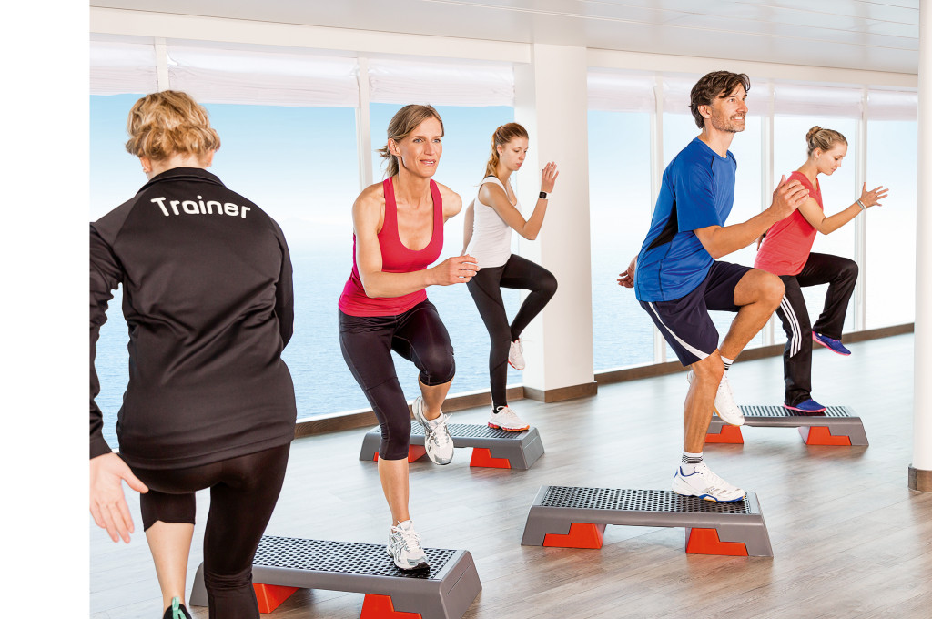 Fitnesscenter mit Schritt-Aerobic-Training, Trainer und Meerblick-Fenster.