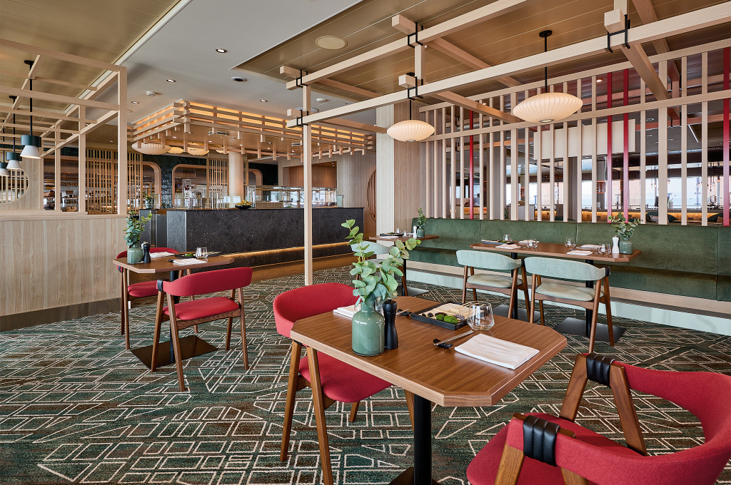 Sitzbereich des Sushi-Restaurants Hedeki mit Holzlatten-Design, Papierlampen und Polsterbank.