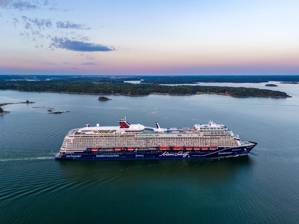 Mein Schiff 7 aus der Vogelperspektive bei Abenddämmerung in einer Schärenlandschaft der Ostsee.