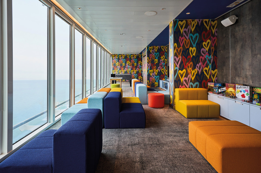 Buntes Kinderspielbereich mit farbigen Sitzmodulen und Meerblick auf dem Kreuzfahrtschiff