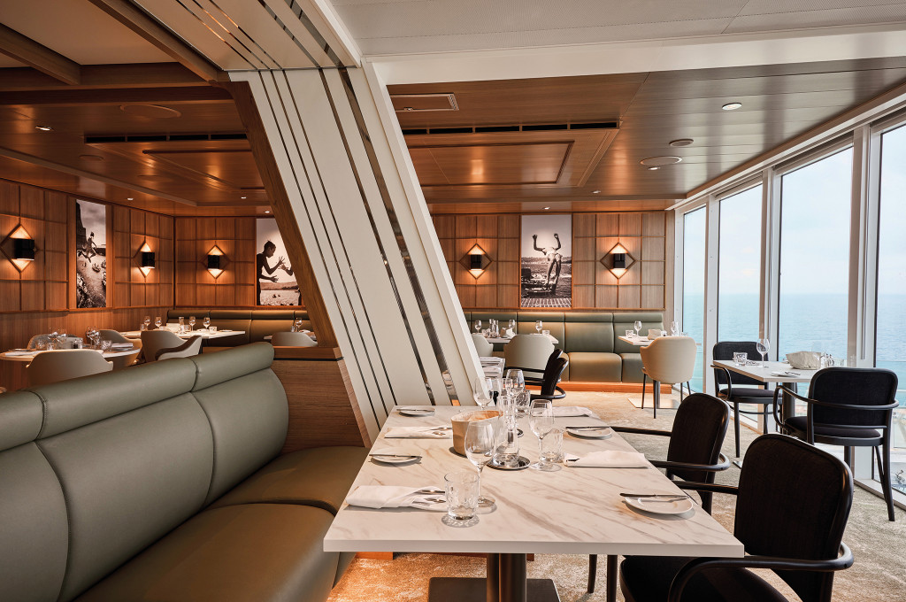 Sitznischen im Osteria mit grüner Polsterbank, Marmortischen und Panoramafenstern zum Meer.