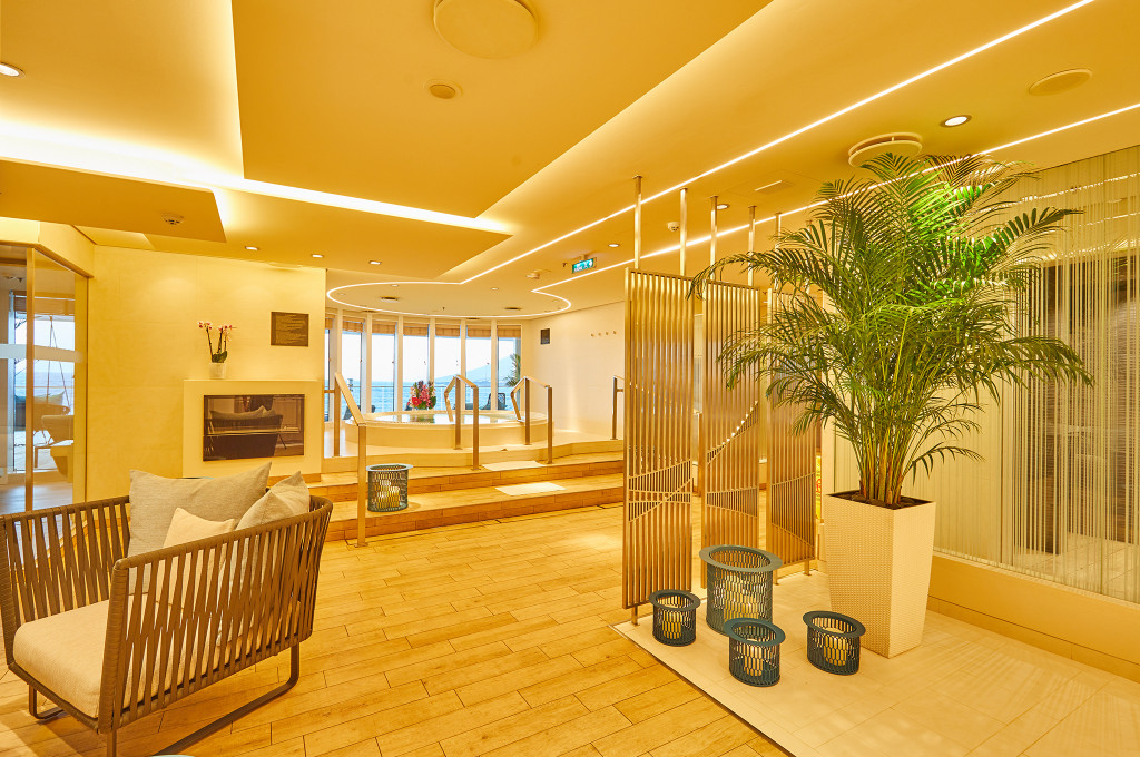 Eingangsbereich des Ocean Spa auf der MS Europa 2 mit Whirlpool, Palme und warmer Holzverkleidung
